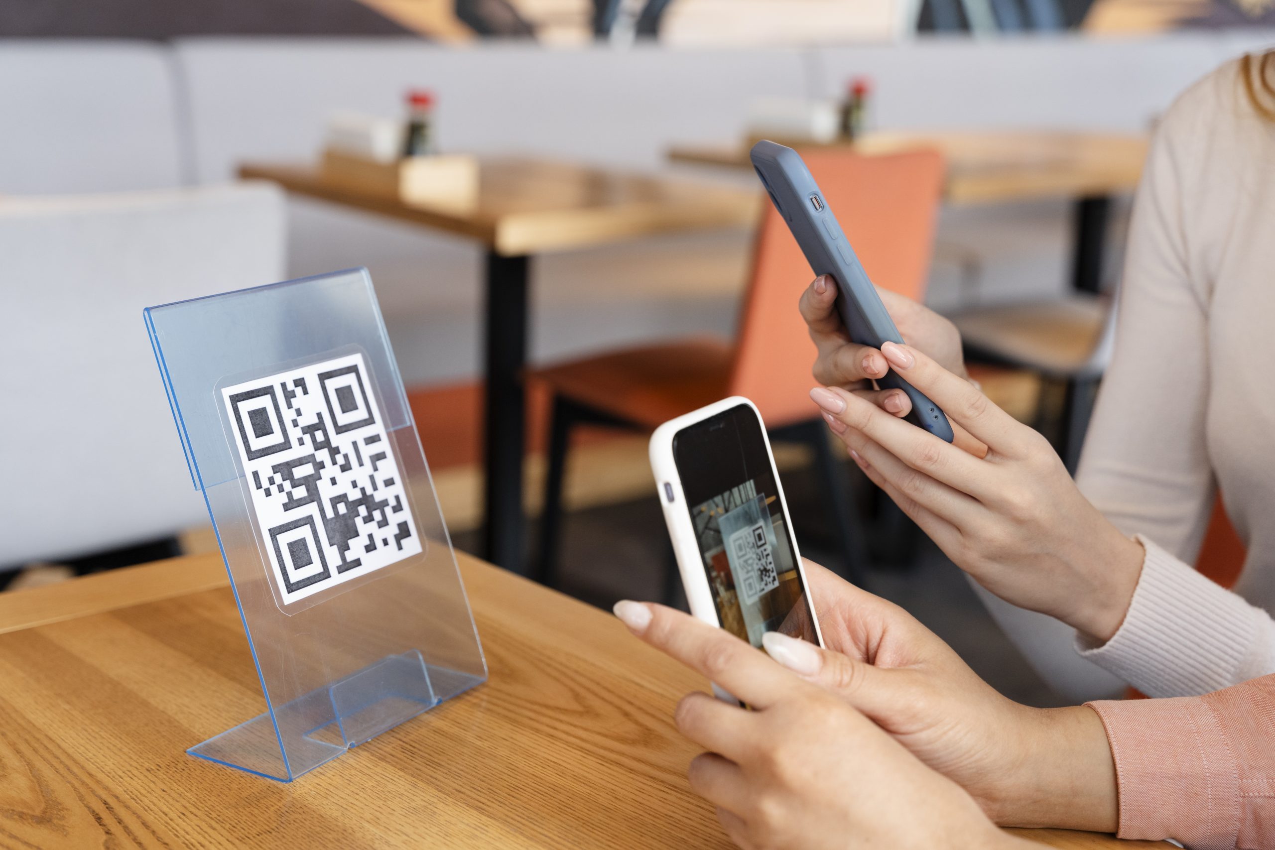 Two people scanning a QR at a restaurant